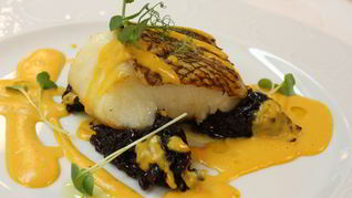 Чилийский сибасс с луковым мармеладом и пряным соусом из батата